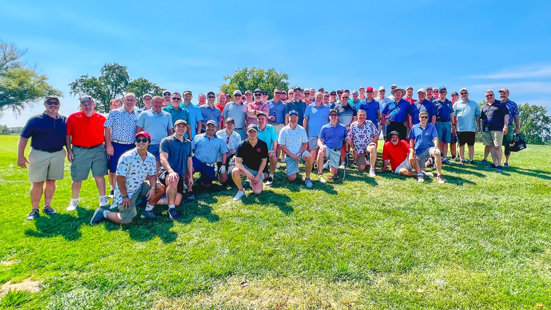 Alumni group photo on the course at the annual golf tournament